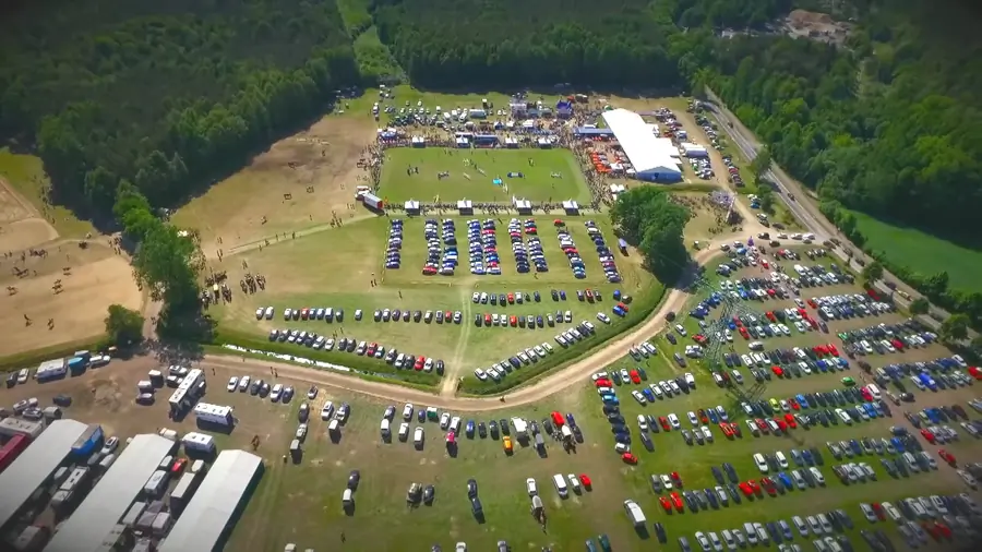 Drohnenaufnahme des Festgeländes beim Pfingstfest in Horka mit Reitplatz, Zelten und parkenden Autos